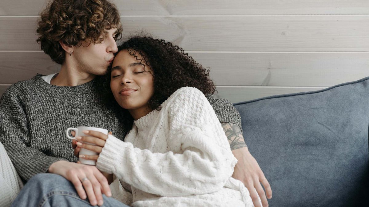 Pareja sentada en un sofá conversando con calma y apoyo mutuo