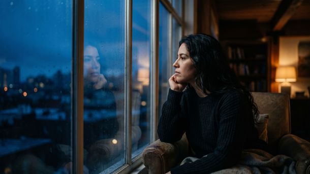 Una mujer reflexiva mirando hacia el horizonte, representando claridad y autoconciencia en la seguridad personal.