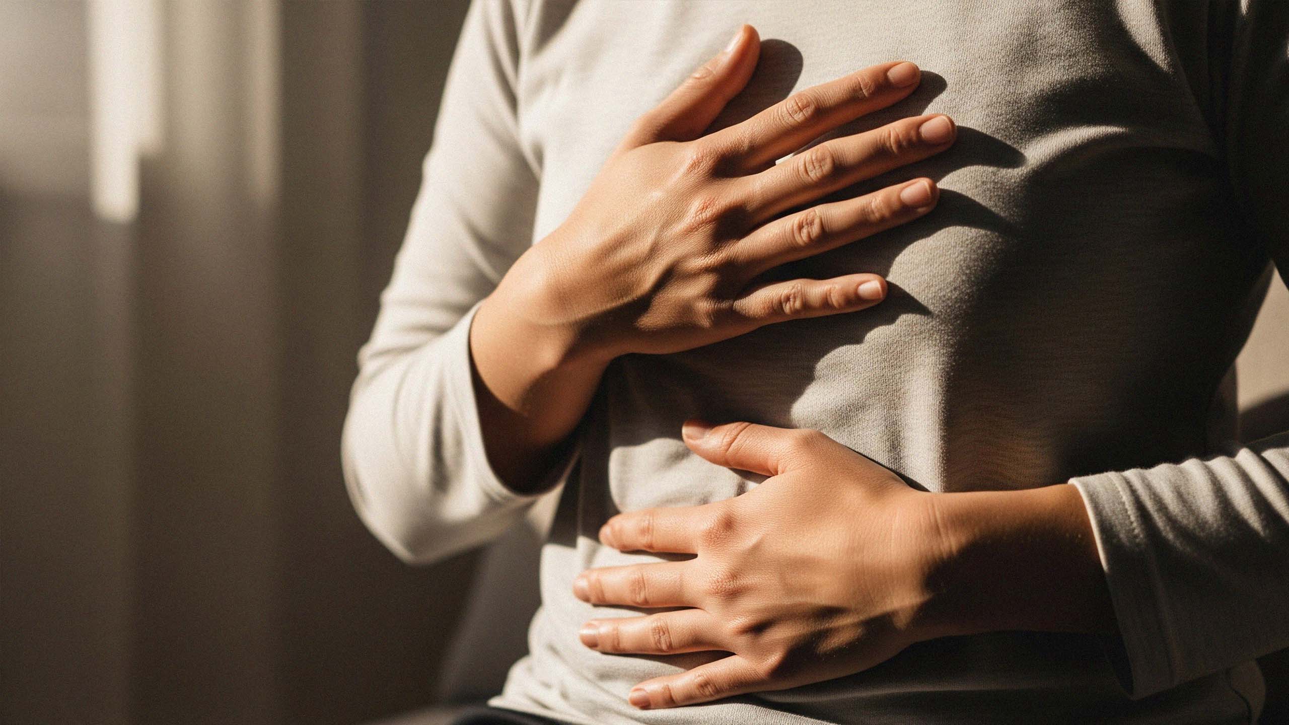 H&auml;nde liegen sanft auf Brust und Bauch, warmes Tageslicht