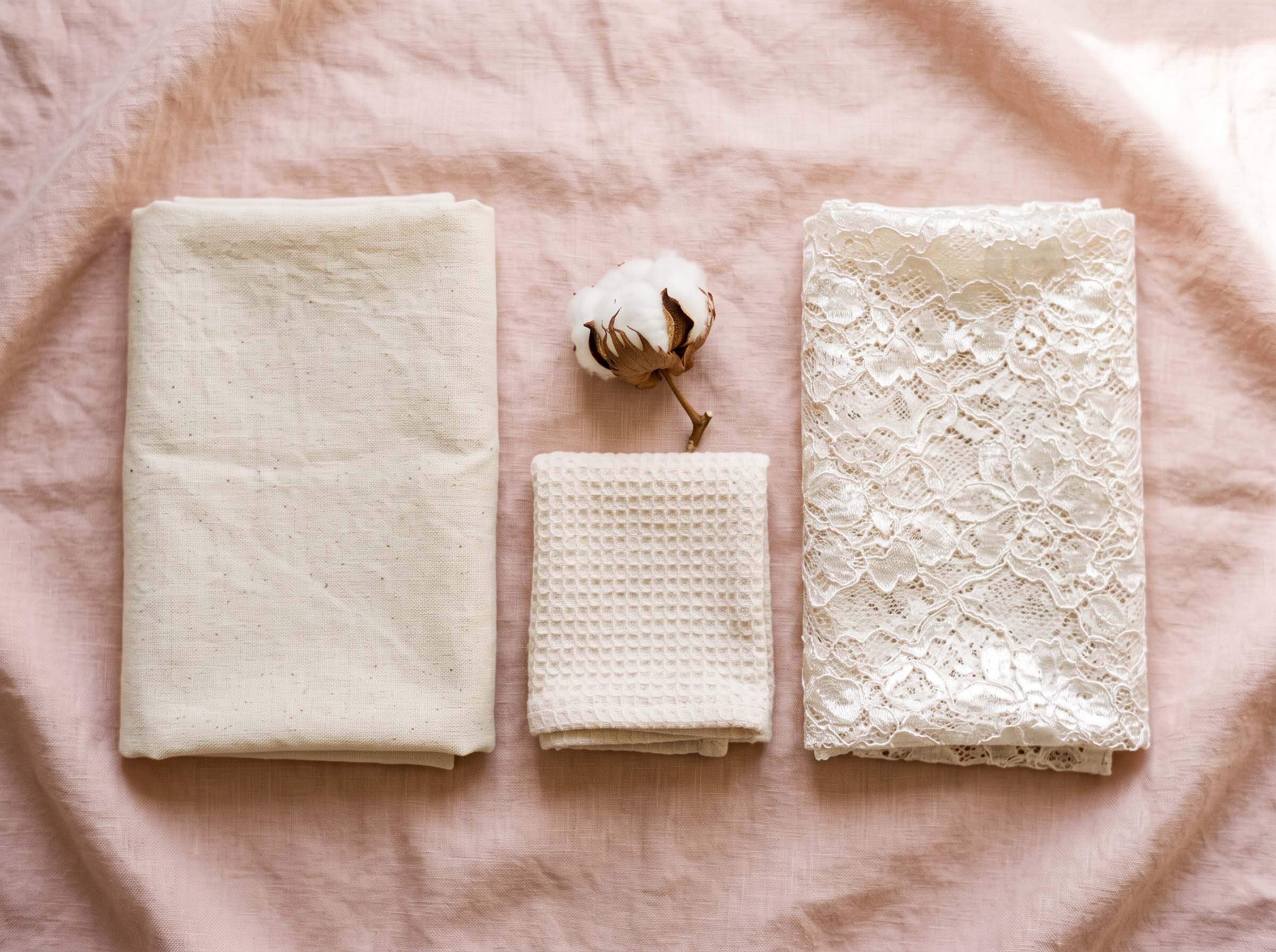 Soft cotton fabric beside a synthetic lace fabric on a pastel surface, illustrating breathable versus non-breathable underwear materials