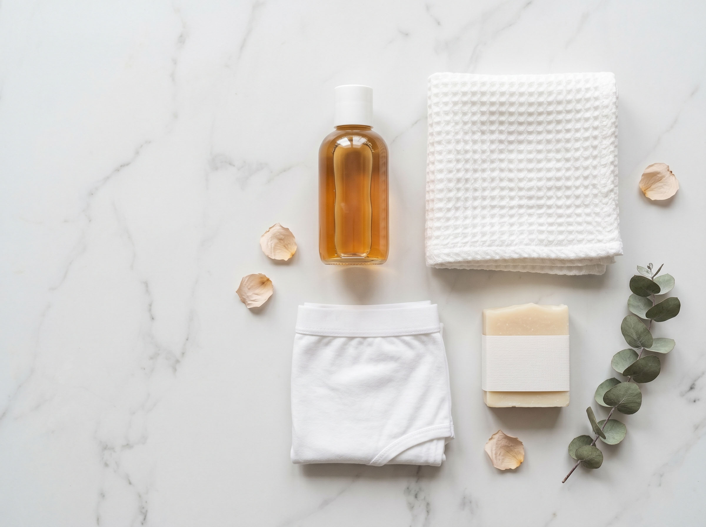 Soft flat lay of gentle, fragrance-free feminine hygiene products on a pastel surface