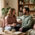 Woman and her partner sitting closely together, sharing a quiet, tender moment of emotional connection at home