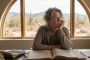Thoughtful 55-year-old woman reflecting on career and family regrets at her accounting desk