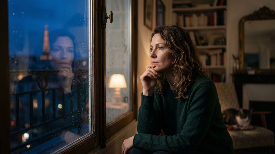 Une femme réfléchie regardant l’horizon, symbolisant la clarté et la conscience de soi en matière de sécurité personnelle.