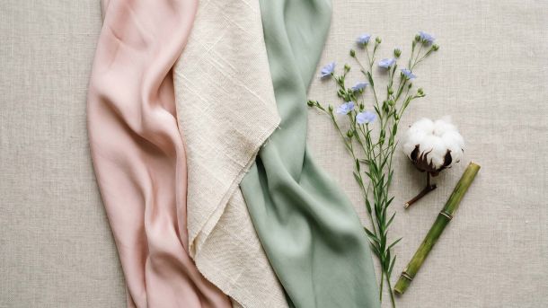 Muestras de tejidos de seda, algodón y bambú dispuestas en una composición femenina tipo flat lay que representa los mejores tejidos para la comodidad íntima femenina