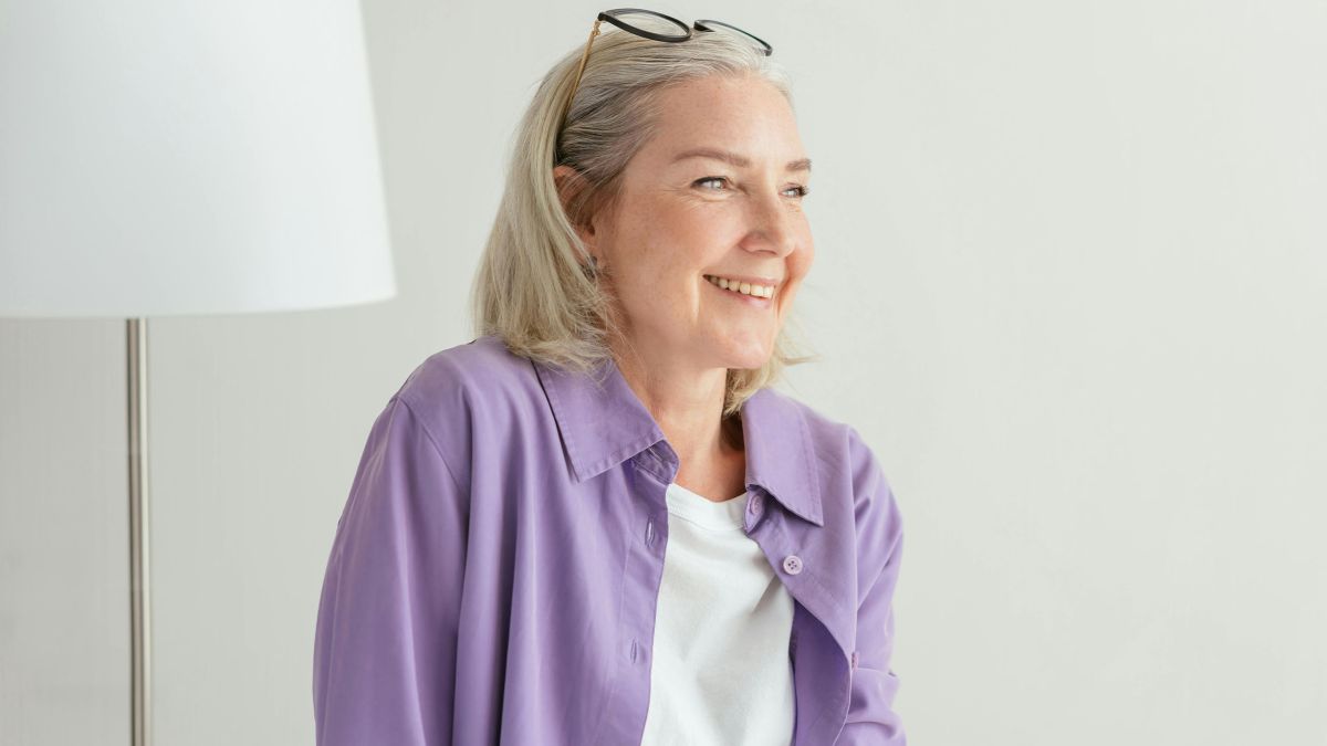 A portrait of a middle-aged woman looking confident and at ease.