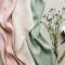 Silk, cotton, and bamboo fabric swatches arranged in a feminine flat-lay representing the best fabrics for women's intimate comfort