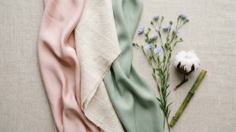 Muestras de tejidos de seda, algodón y bambú dispuestas en una composición femenina tipo flat lay que representa los mejores tejidos para la comodidad íntima femenina
