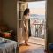 Woman in a linen robe at a hotel balcony doorway in morning light, reflecting on why travel doesn't restore closeness in a marriage