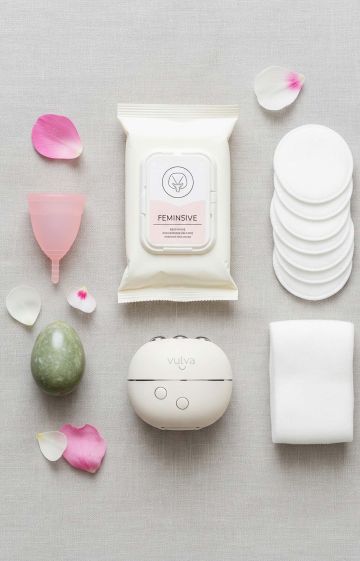Collection of vulva and vagina care products including intimate wash, menstrual cup, lubricant, and feminine wipes on a neutral background