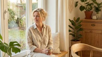 Eine Frau praktiziert achtsames Atmen in einem hellen, friedlichen Raum zur Stressreduktion.