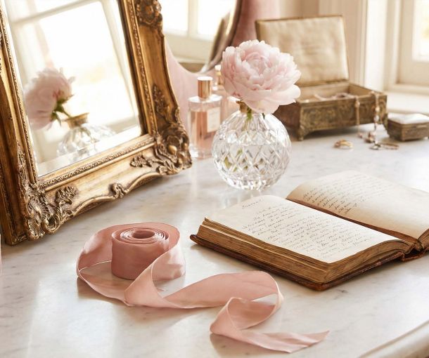 Eine elegante feminine Schminkkommode mit goldenem Spiegel und Tagebuch, die die Geschichte privater weiblicher Bildung und Gesundheit symbolisiert.