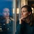 Woman sitting alone looking out a window in quiet reflection