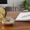 A compass on a wooden desk next to a planner, symbolizing strategic career and family life planning.