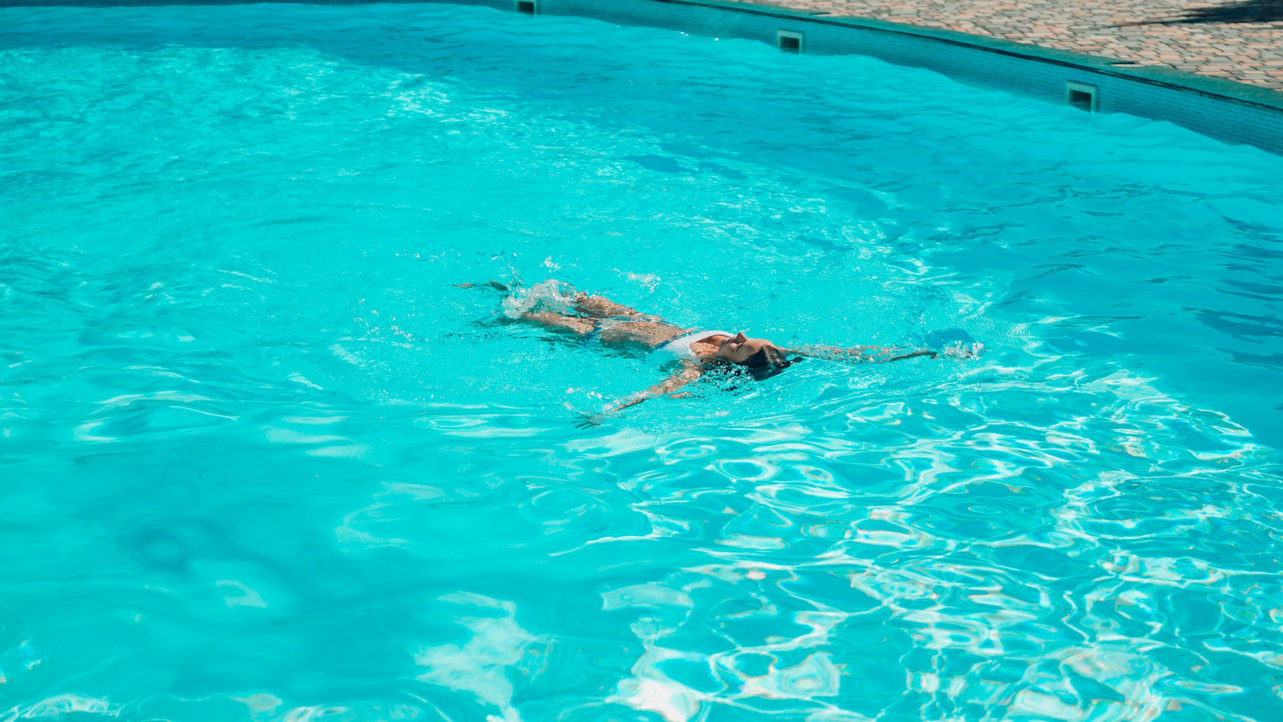 Mujer nadando en una piscina clorada clara